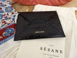 a black wallet sitting on top of a table next to a white bag