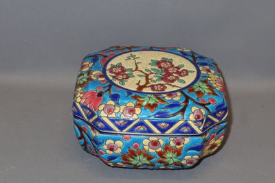 a small blue box with flowers on it on a table