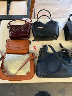 many different purses on a table in a store