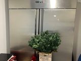 un sapin de Noël dans une boîte, à côté d'un réfrigérateur