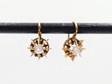 une photo d'une paire de boucles d'oreilles en or serties de diamants