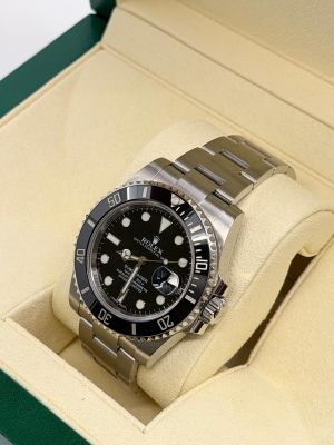 une montre Rolex dans son coffret, posée sur une surface blanche