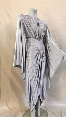 robe grise drapée sur un mannequin, sur fond blanc