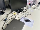 a laptop computer sitting on a desk with a monitor and a mouse