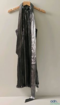 a black dress hanging on a hanger on a wall