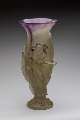 a glass vase with a bird on it on a table