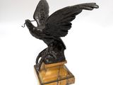 an image of a statue of a bird on a wooden base