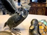 statue of an owl and a turtle sitting on a table