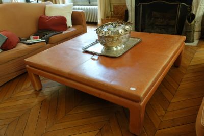 une table basse au milieu d'un salon avec deux canapés et une cheminée