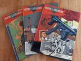 three books on a wooden table with a gun on top of them