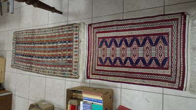 de nombreux tapis accrochés au mur dans une pièce