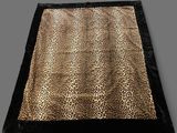 a leopard print blanket on a grey background