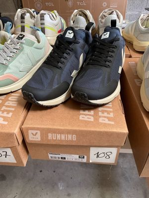 several pairs of running shoes sitting on top of boxes in a store