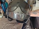 a person holding a motorcycle helmet on top of a pile of clothing