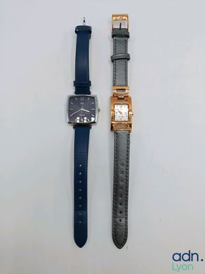 les deux montres sont posées l'une à côté de l'autre sur une surface blanche