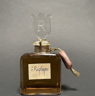 a bottle of perfume with a bird on top of it