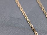 a close up of a gold chain on a black surface