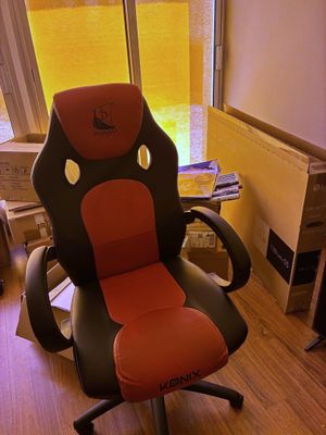 une chaise de bureau rouge et noire placée devant une fenêtre