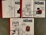 three books with drawings of people on them sitting on a table