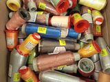 a box full of different colored threads and spools