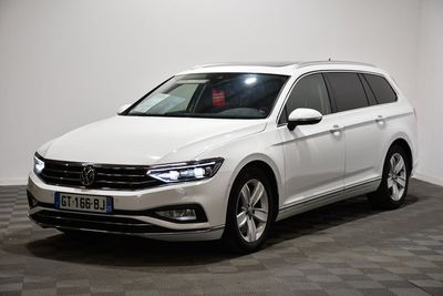 La Volkswagen Passat blanche est garée dans une pièce dont le sol est à carreaux.