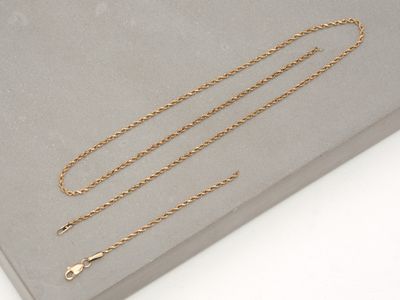 a close up of a gold chain on a gray surface