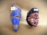 two masks that are on the wall next to each other