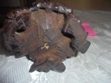 a small wooden object on a table with a pink piece of paper