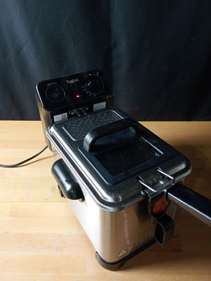 a silver and black fryer sitting on a wooden table