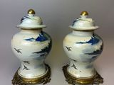 pair of blue and white vases with birds on them on a white surface