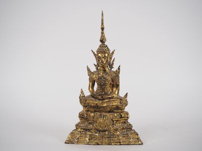 une statue en or représentant une personne assise sur un rocher