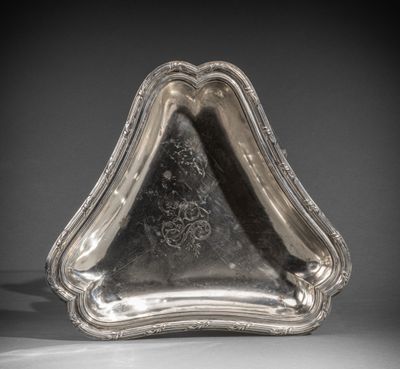 une assiette en argent ornée d'un motif sur le bord