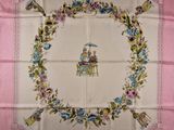 une photo d'une nappe rose sur laquelle figure une femme assise sur une chaise