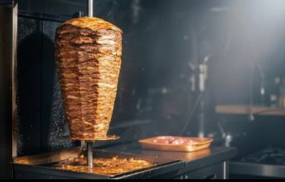 un kebab en train de cuire sur une brochette dans une cuisine