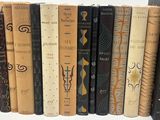 many books that are lined up together on a shelf