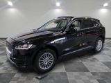 Le SUV Jaguar noir est garé sur un sol en carrelage à damier.