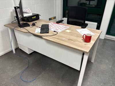 un bureau sur lequel se trouvent un ordinateur, un clavier, une souris et une imprimante