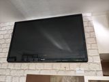 une télévision à écran plat fixée au mur au-dessus d'une cheminée