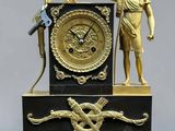 a statue of a man holding a sword and a clock on a table