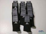 trois paires de chaussettes noires ornées de logos noirs et blancs
