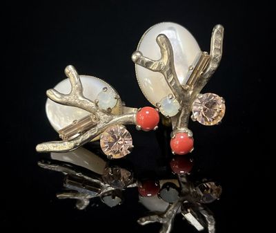 paire de boucles d'oreilles en argent et corail sur fond noir avec reflets