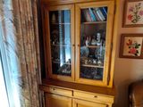 une armoire en bois avec une porte vitrée dans un salon