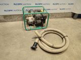 the hose is next to the pump on the floor in front of the wall