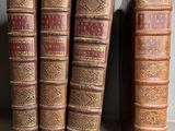 plusieurs vieux livres sont alignés sur une étagère, les uns à côté des autres
