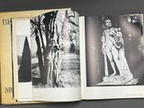 an open book with a black and white photo of a man standing next to a tree