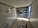 an empty room with a shelf and a chair in it