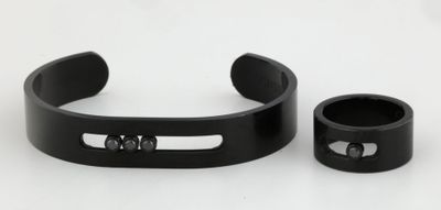 a close up of a pair of black bracelets on a white surface