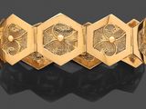 un bracelet en or 18 carats orné d'hexagones et de fleurs