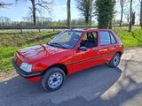 La voiture rouge est garée sur le bord de la route.