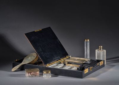 une valise noire contenant un miroir, une brosse et d'autres objets